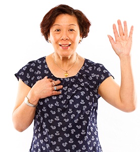 woman pointing at herself with her hand raised