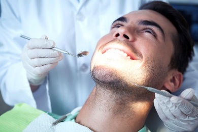 man having his teeth looked at by a dentist