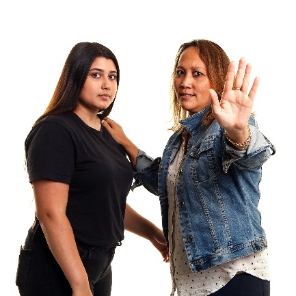 woman with her hand out as if to say stop holding another woman.