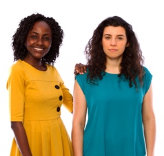 woman with her hand on another woman's shoulder. they are smiling